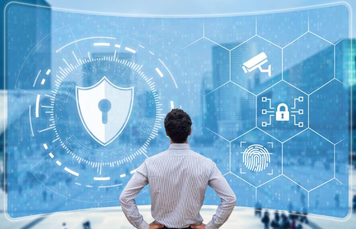 Man standing in front of the big transparent screen with cybersecurity controls on it