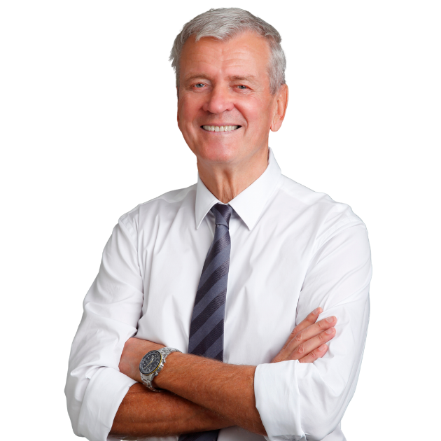 A man in a white shirt and tie smiles warmly at the camera.